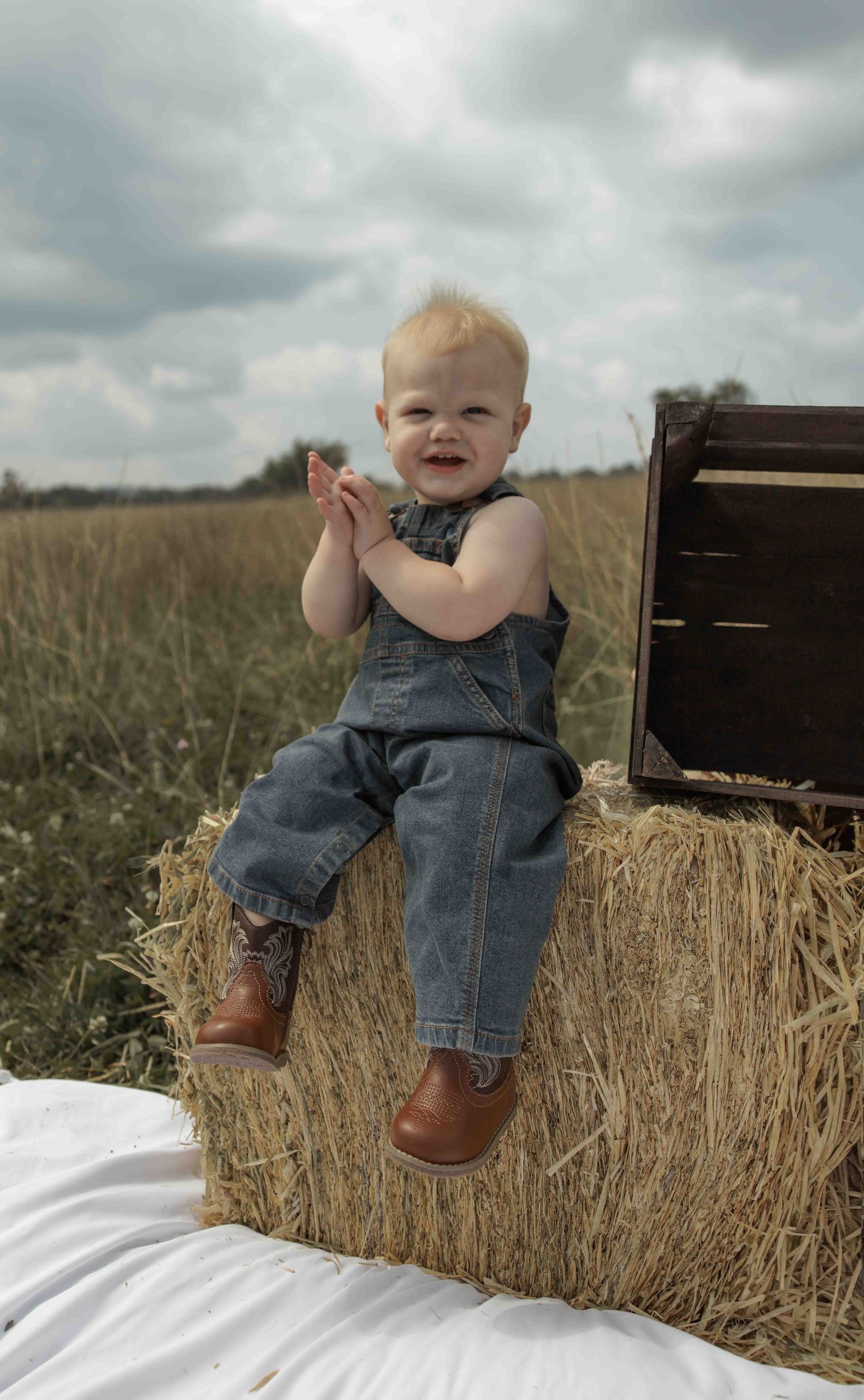 Central PA first birthday photography session featuring a little cowboy celebrating with a western-themed cake smash, cowboy hat, and boots.