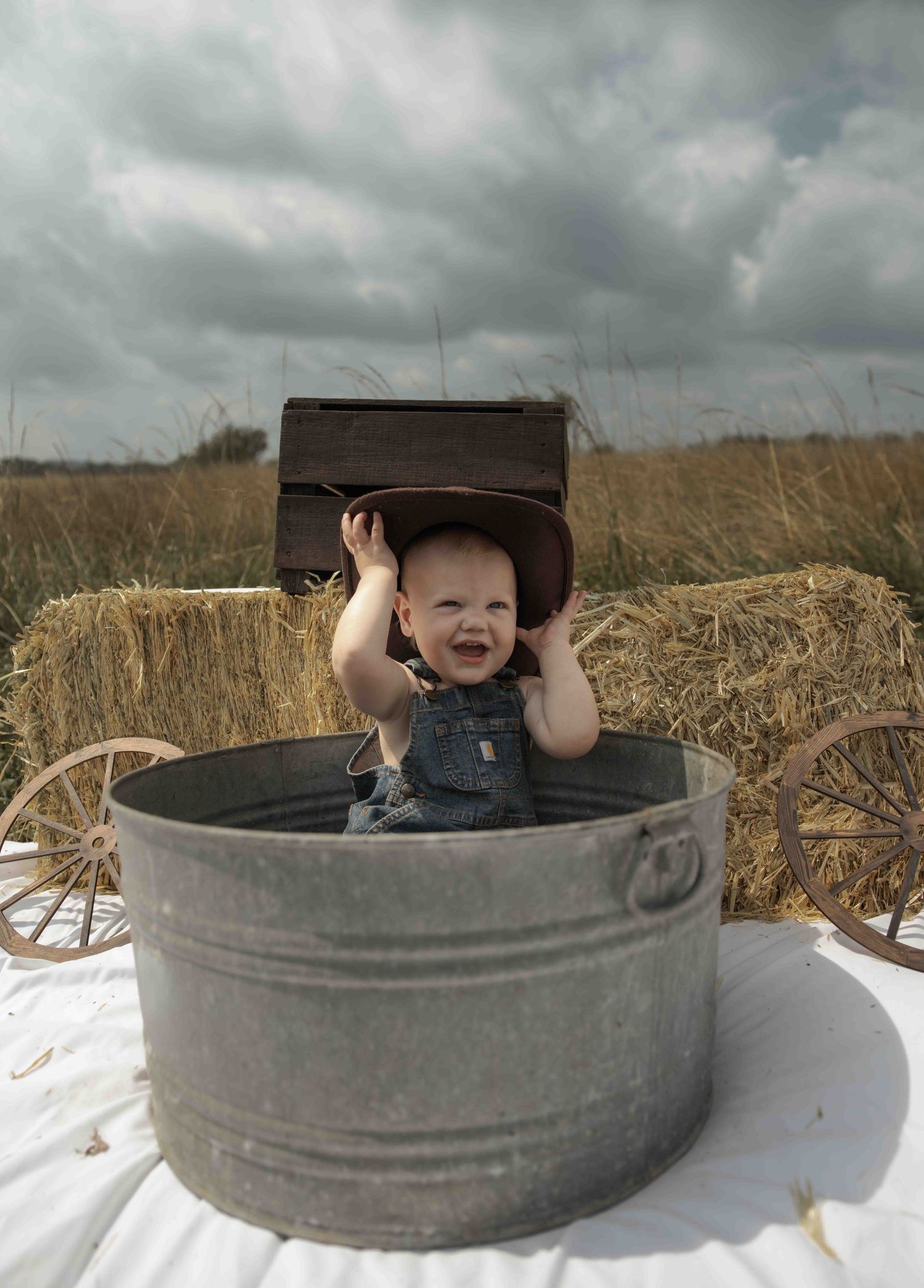 Central PA first birthday photography session featuring a little cowboy celebrating with a western-themed cake smash, cowboy hat, and boots.