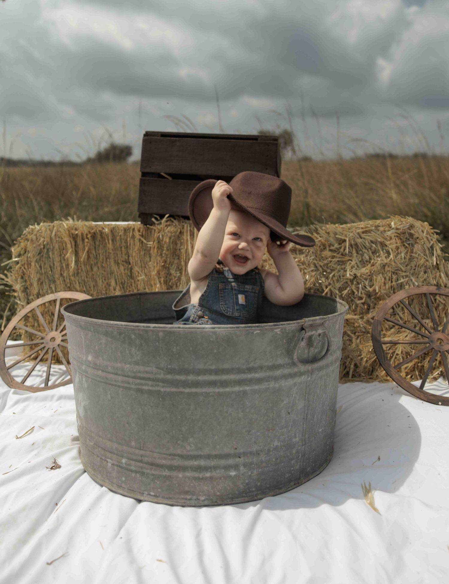 Central PA first birthday photography session featuring a little cowboy celebrating with a western-themed cake smash, cowboy hat, and boots.