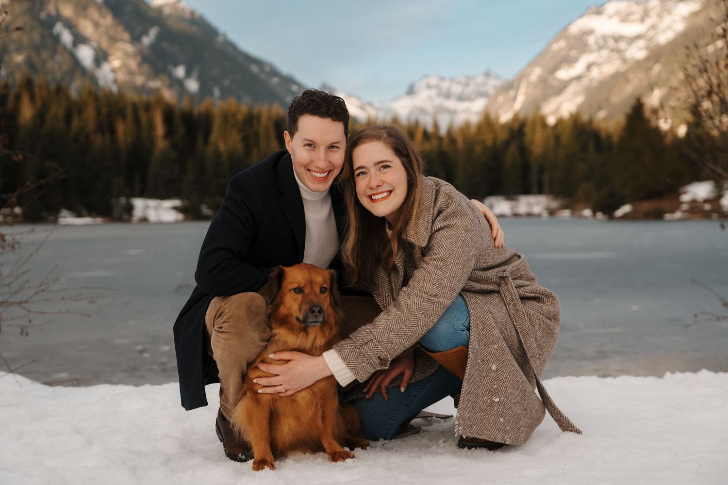 Samantha and Chase with their dog at their snowy gold creek pond engagement session in winter time.