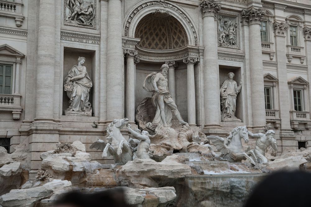 The iconic Trevi Fountain in Rome, Italy, featuring Neptune statue surrounded by horses and elaborate Baroque architecture.