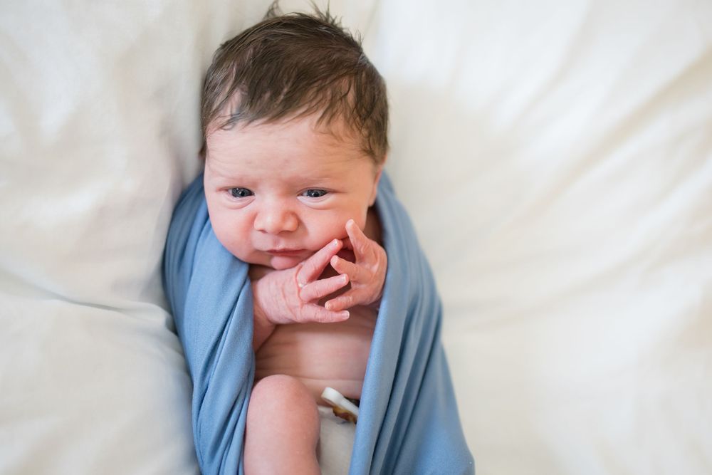 Newborn baby wrapped in a soft blue swaddle during a Fresh 48 Session at Fort Sanders in Knoxville, TN.