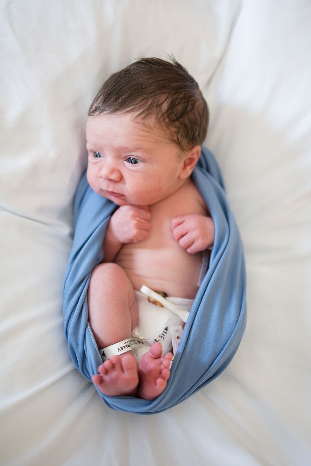 Newborn baby wrapped in blue swaddle during a Fresh 48 Session at Fort Sanders in Knoxville, TN.