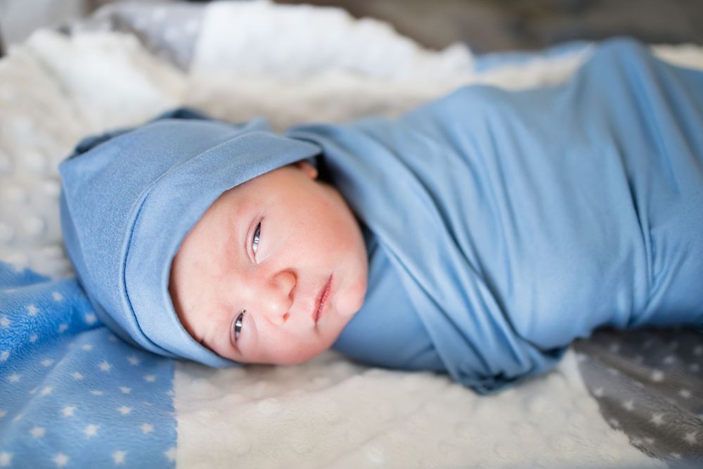 Newborn baby swaddled in blue wrap during a Fresh 48 Session at Fort Sanders in Knoxville, TN.