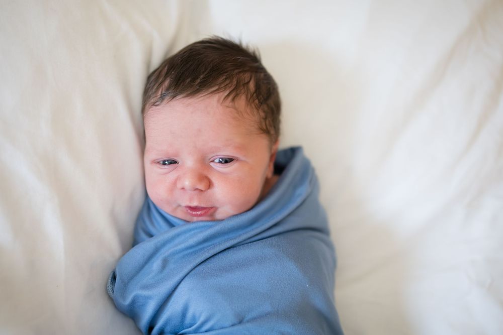 Newborn baby swaddled in a blue blanket during a Fresh 48 Session at Fort Sanders in Knoxville, TN.