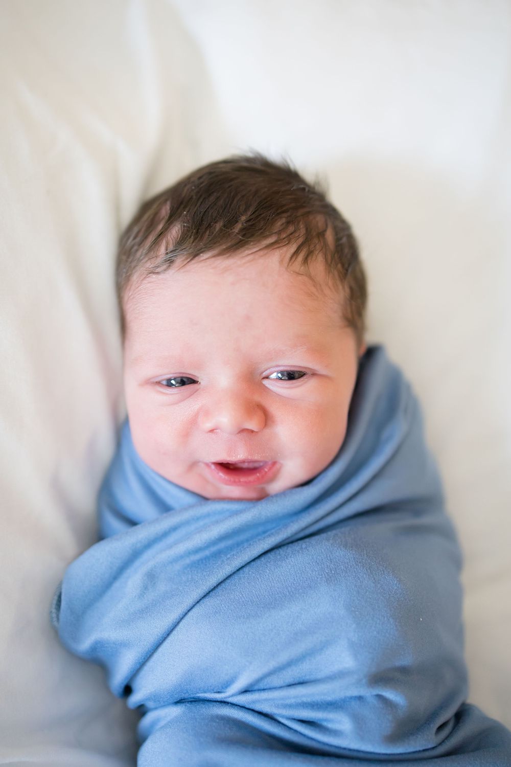 Newborn baby swaddled in a blue blanket withduring a Fresh 48 Session at Fort Sanders in Knoxville, TN.