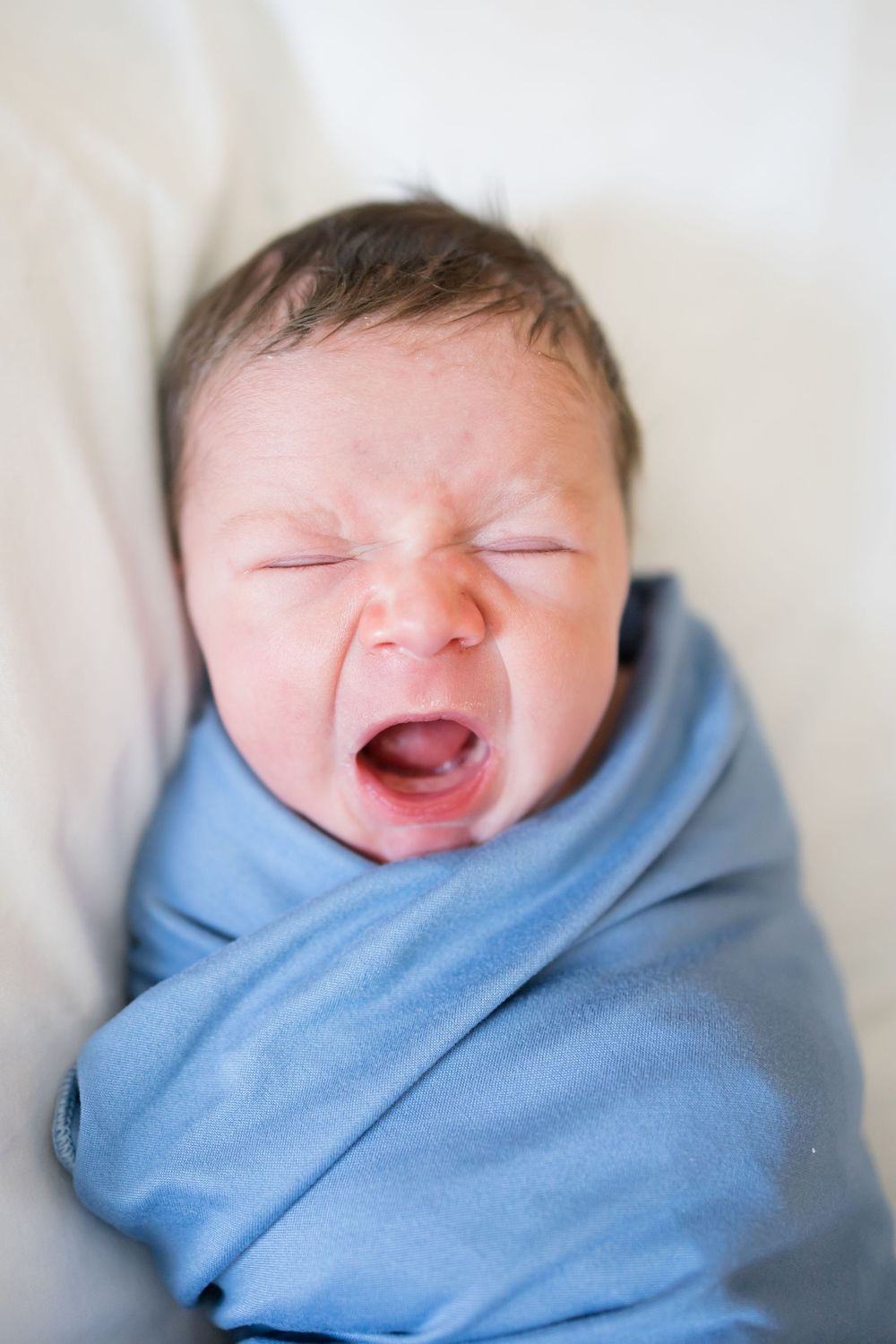 Newborn baby swaddled in blue blanket during a Fresh 48 Session at Fort Sanders in Knoxville, TN.
