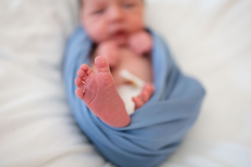 Newborn baby swaddled in a soft blue wrap during a Fresh 48 Session at Fort Sanders in Knoxville, TN.