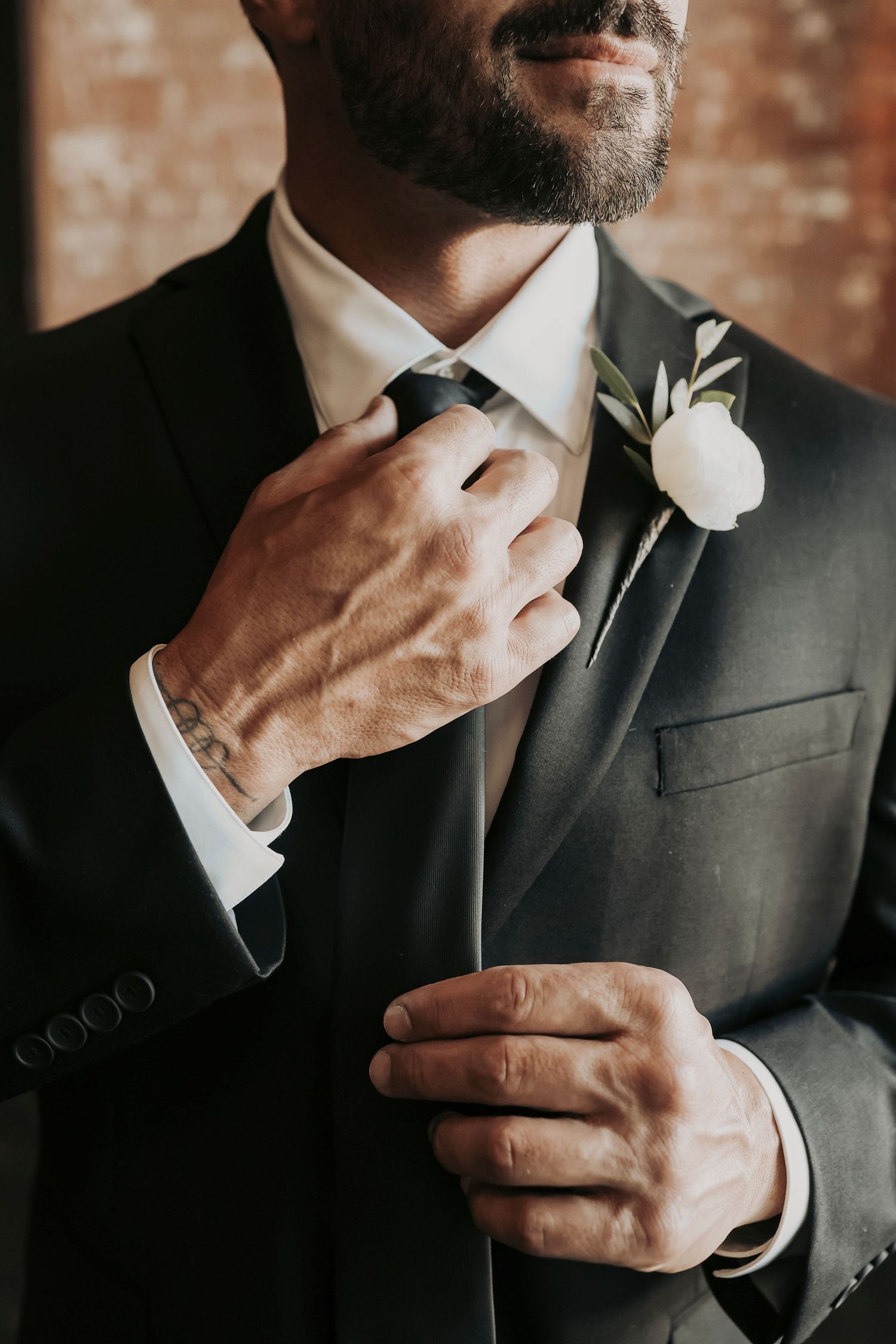 Abe helping Joel with his boutonniere before the wedding