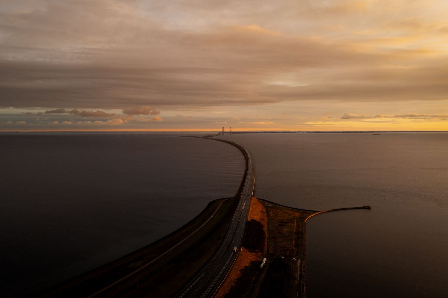 Stemningsfuldt dronefotografi af kystlandskab og vej i gyldent aftenlys – landskabsfotografi og kunstprint.