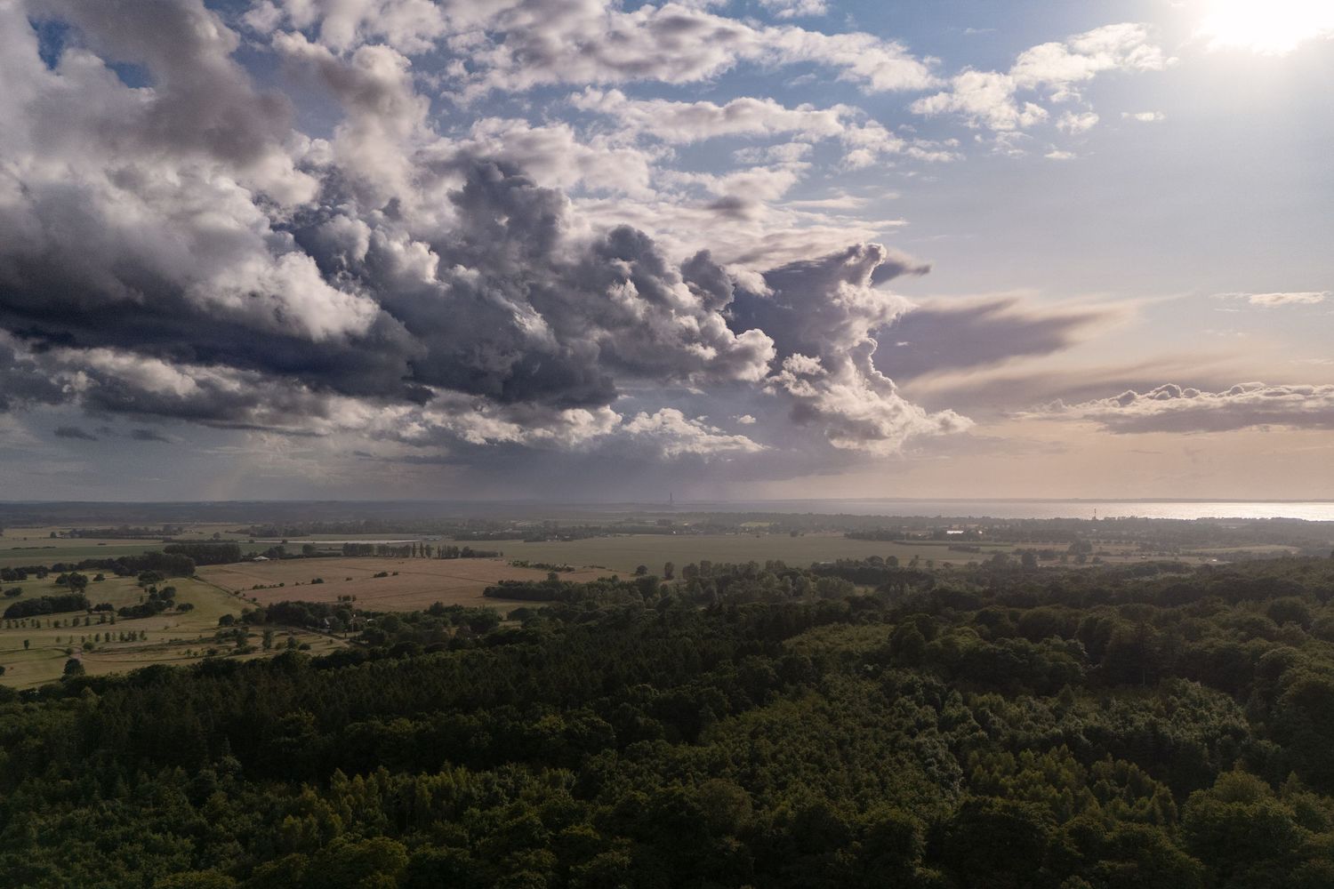 Luftfoto af åbent landskab under dramatisk himmel – nordisk landskabsfotografi og kunstprint til hjem og erhverv.