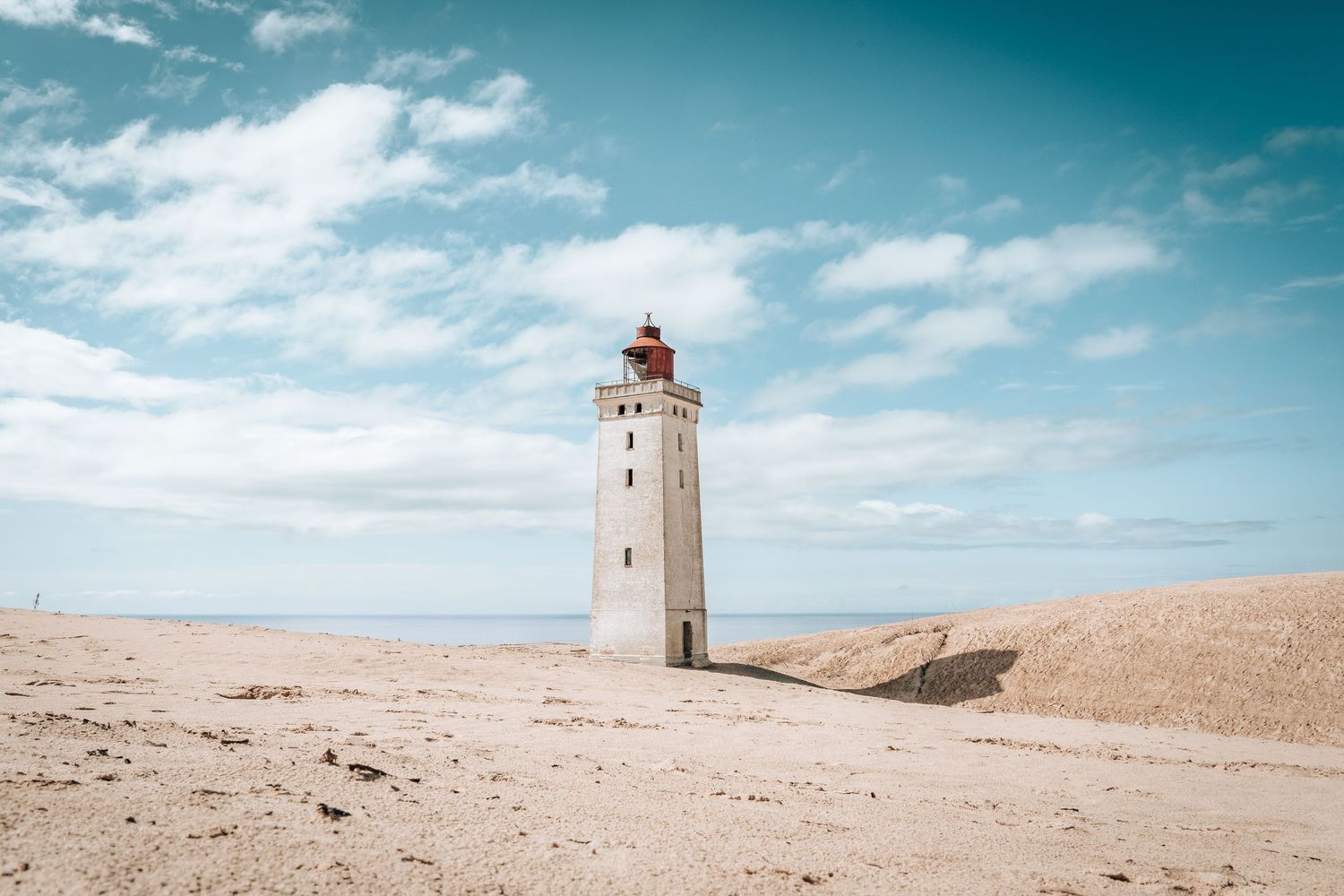 Fotokunst med fyrtårn i lyst klitlandskab – nordisk kystfotografi og fotoplakat til hjemmet.