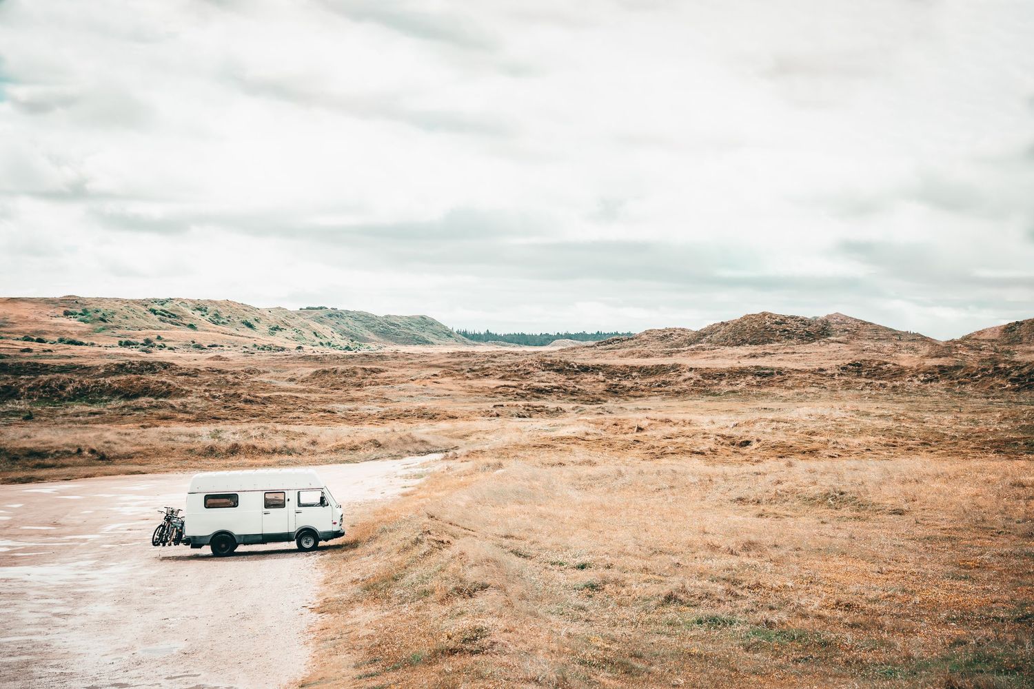 Landskabsfotografi med campingvogn i åbent, råt terræn – nordisk fotokunst og fotoplakat til hjemmet.