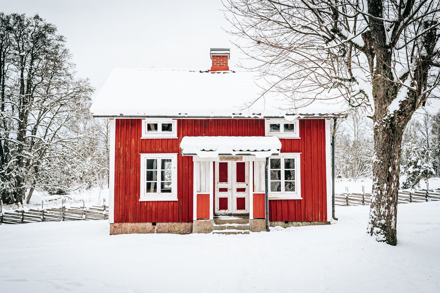 Vinterfotografi af rødt svensk træhus i sne – nordisk fotokunst og stemningsfuld vinterplakat til hjemmet.