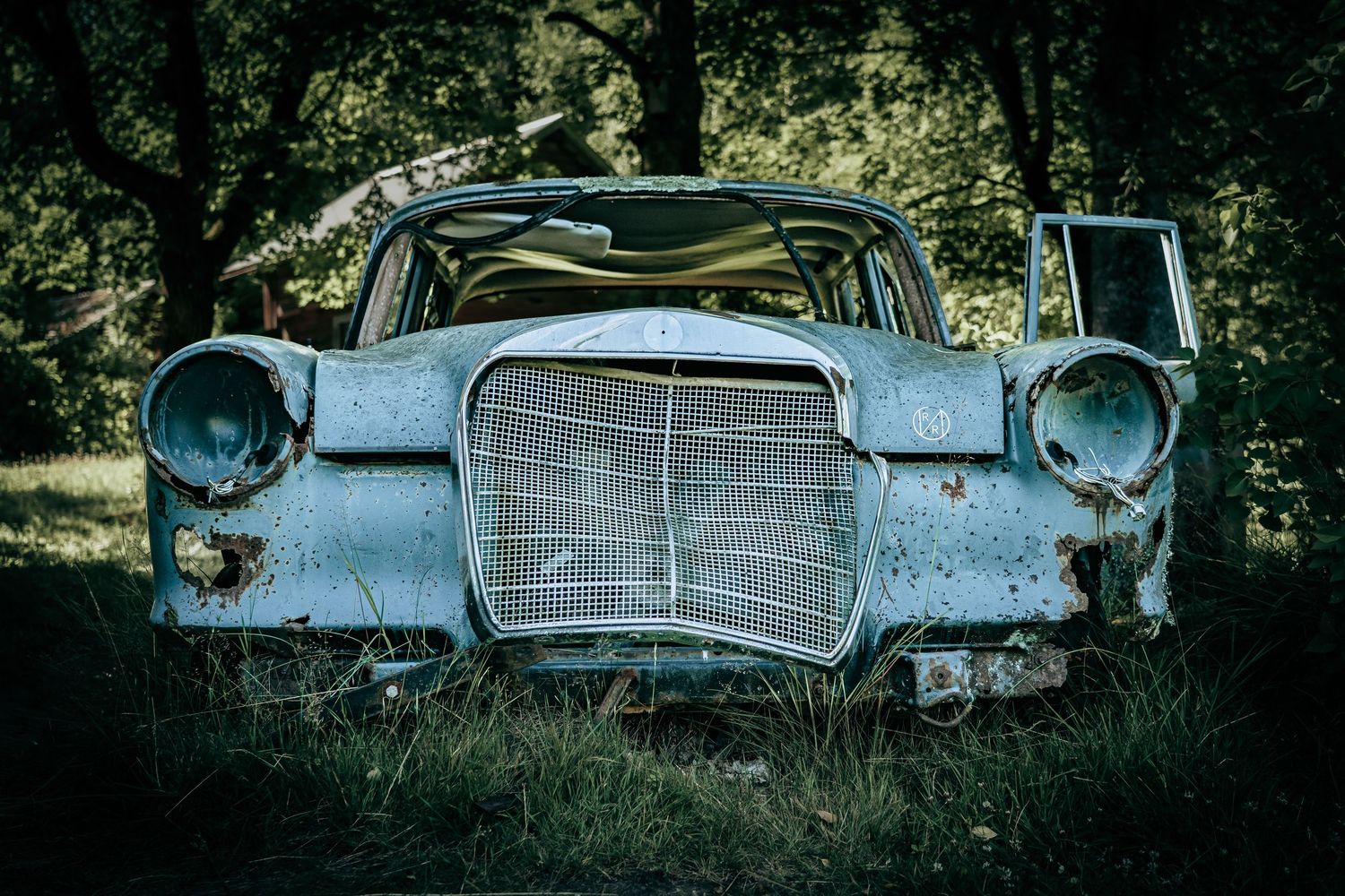 Fotografi af gammel forladt Mercedes i skoven – rå og stemningsfuld fotokunst som plakat til hjem og erhverv.