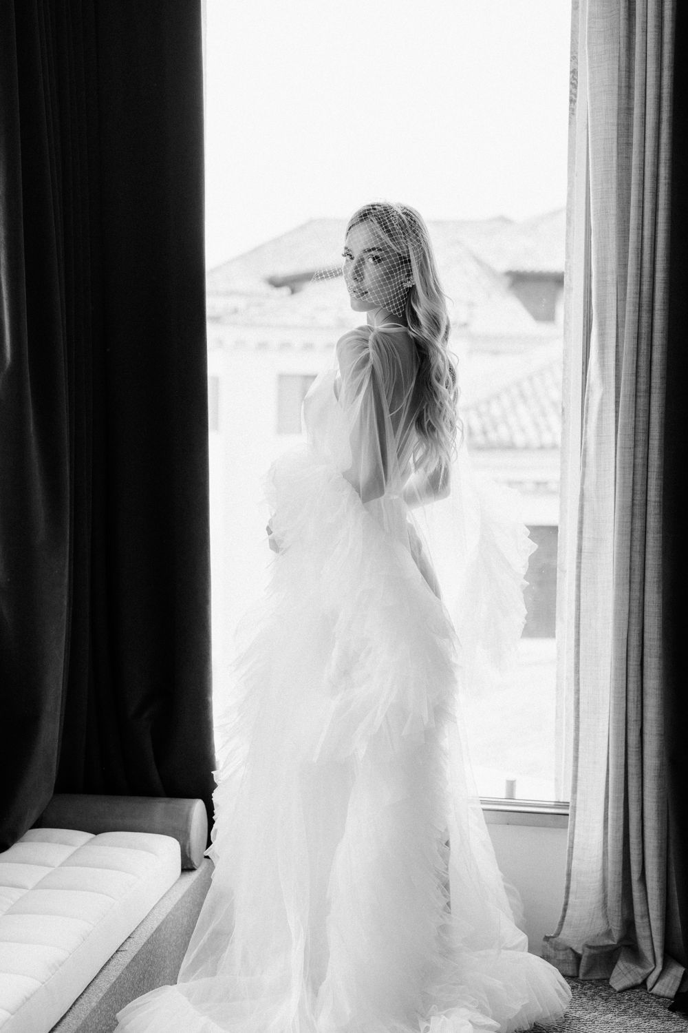 Artistic black and white series of a bride in silhouette against a bright window.