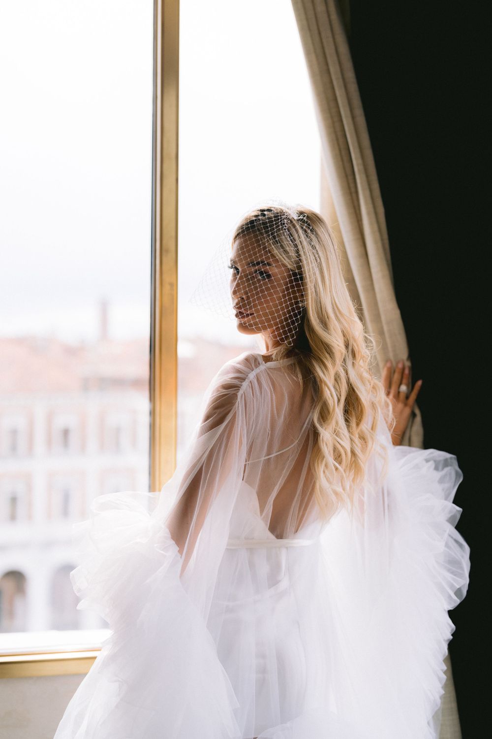 Romantic bridal portraits with soft window light showing delicate veil details.