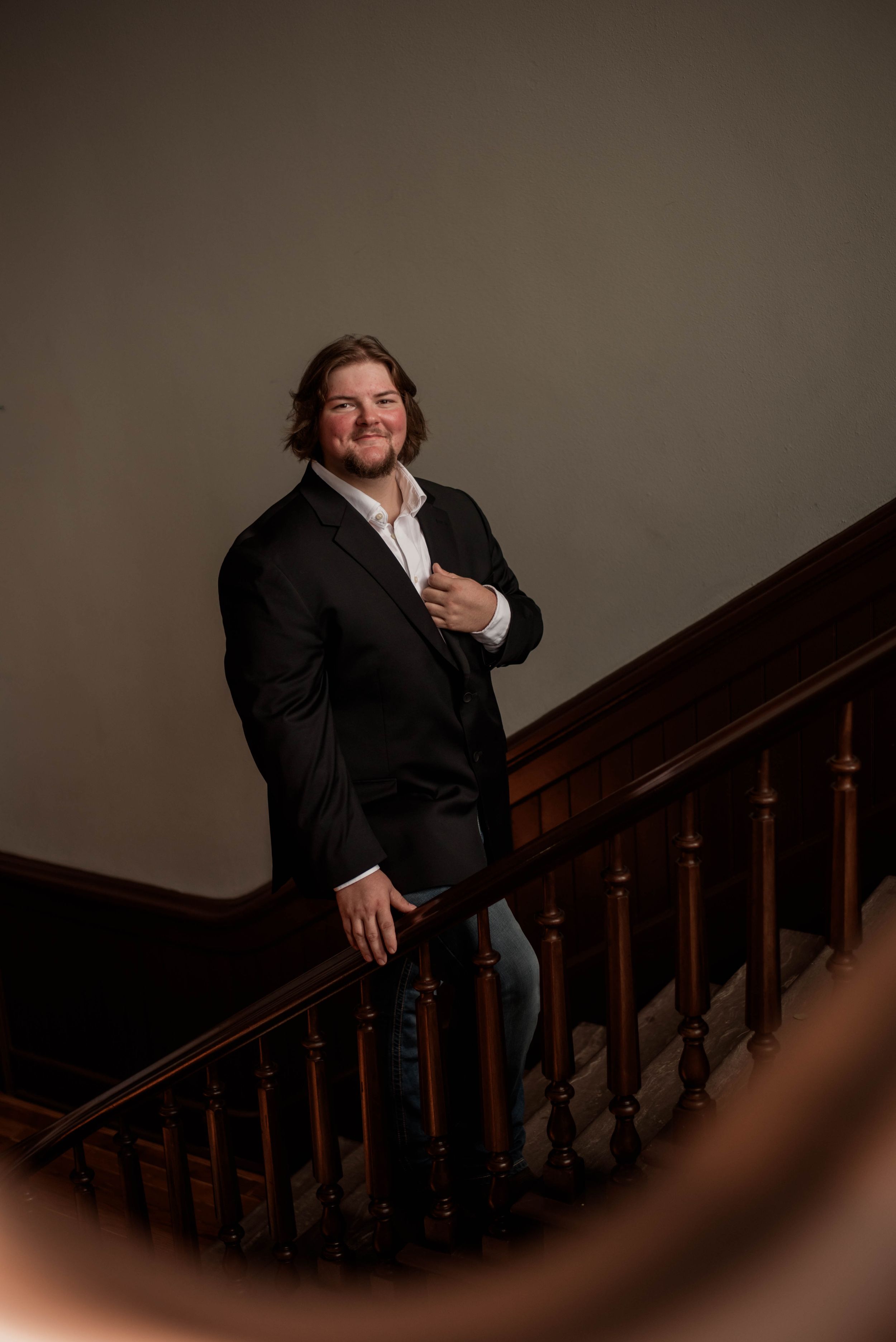 Groom smiles on the wooden staircase inside the Weatherford Courthouse before his wedding ceremony.