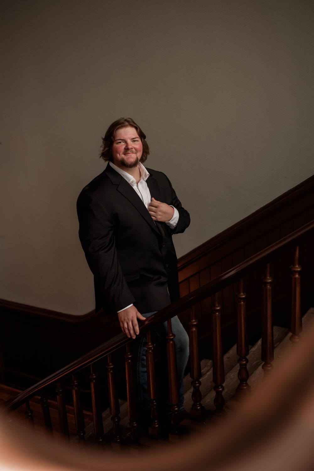 Groom smiles on the wooden staircase inside the Weatherford Courthouse before his wedding ceremony.