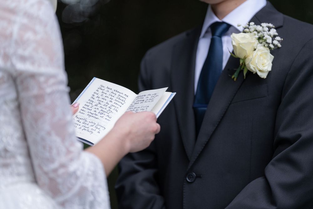 Bride reading handwritten vows from a small notebook at Colab Gardens, Stuart, FL