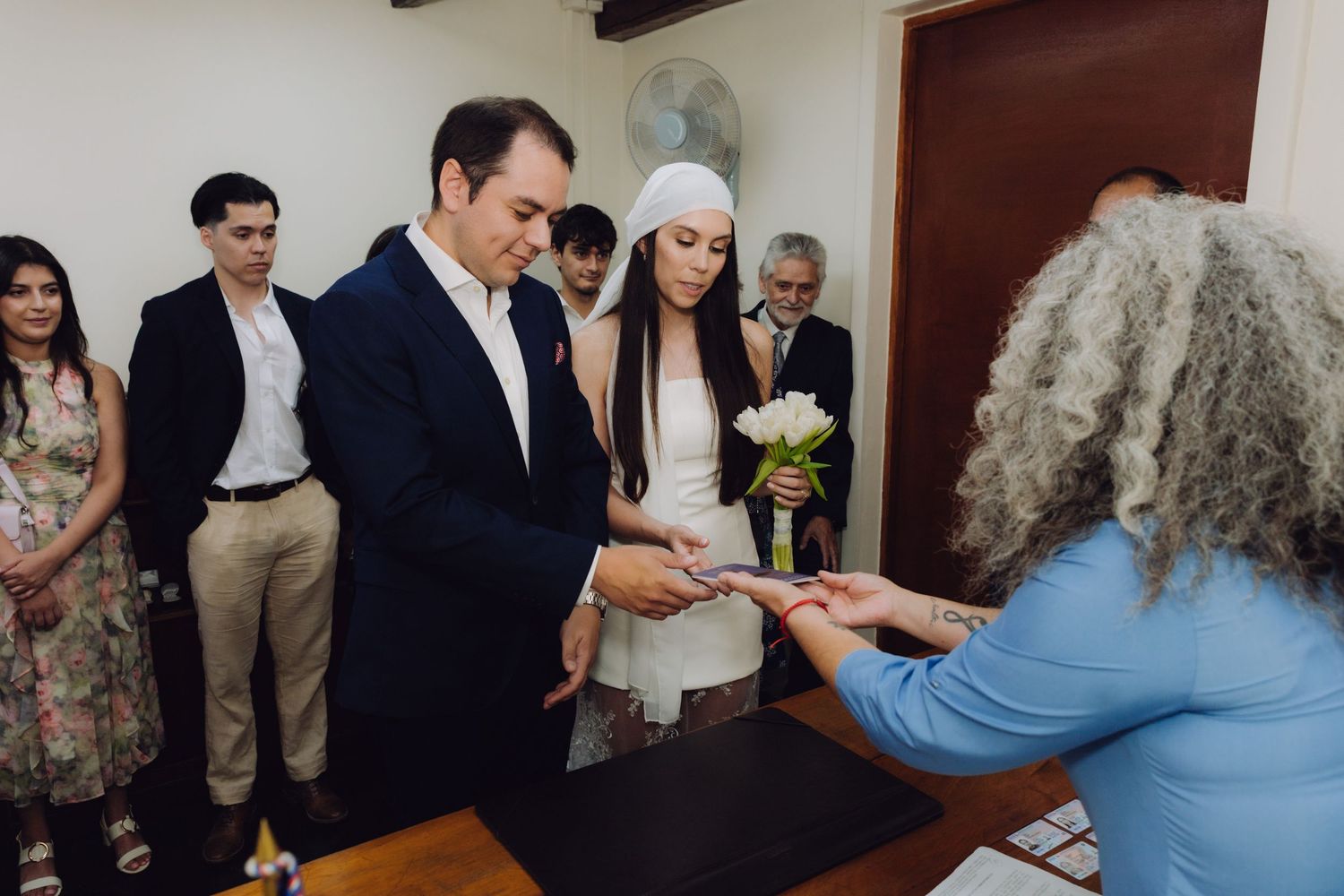 Bride and groom receive documents from officiant during civil wedding ceremony.