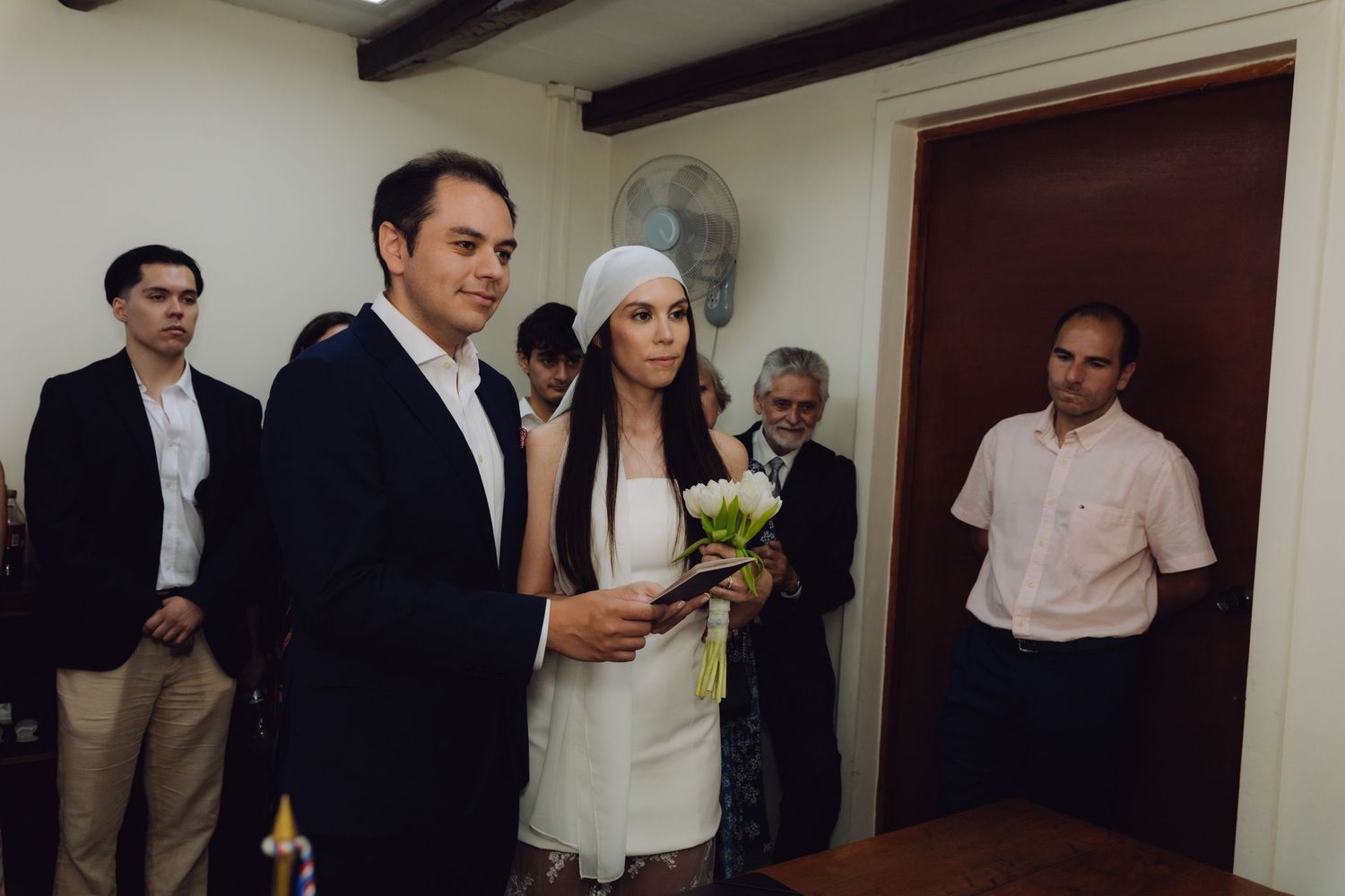 Couple stands together reading during intimate indoor civil wedding ceremony.