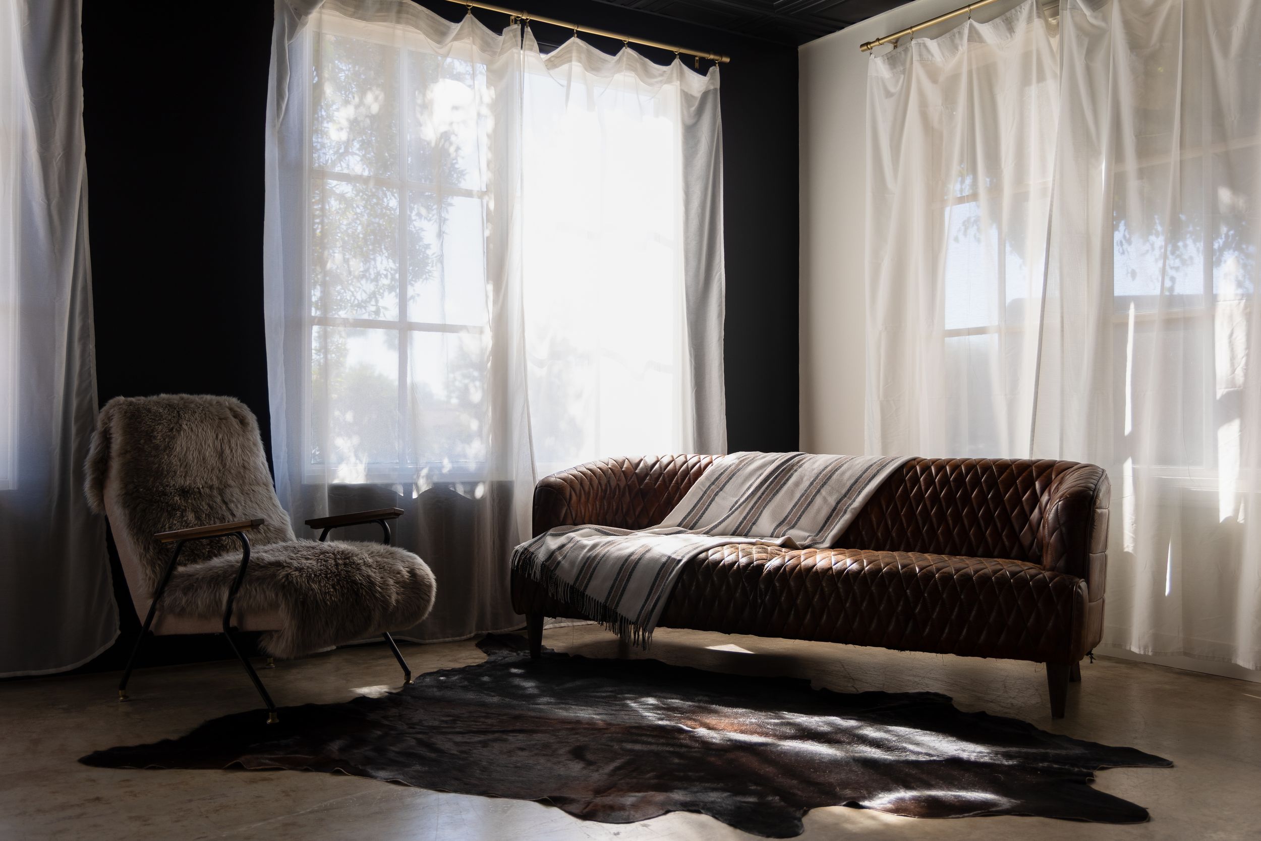 Luxury boudoir photography setup featuring a leather couch and fur chair