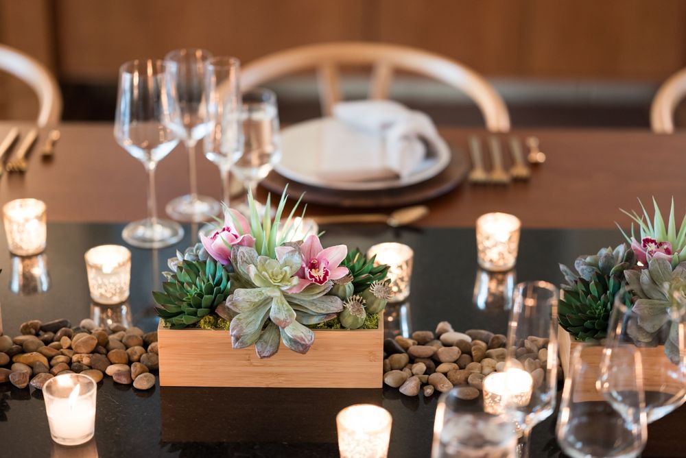 Rustic dining table decorated with wooden succulent boxes, tea lights, and natural elements.