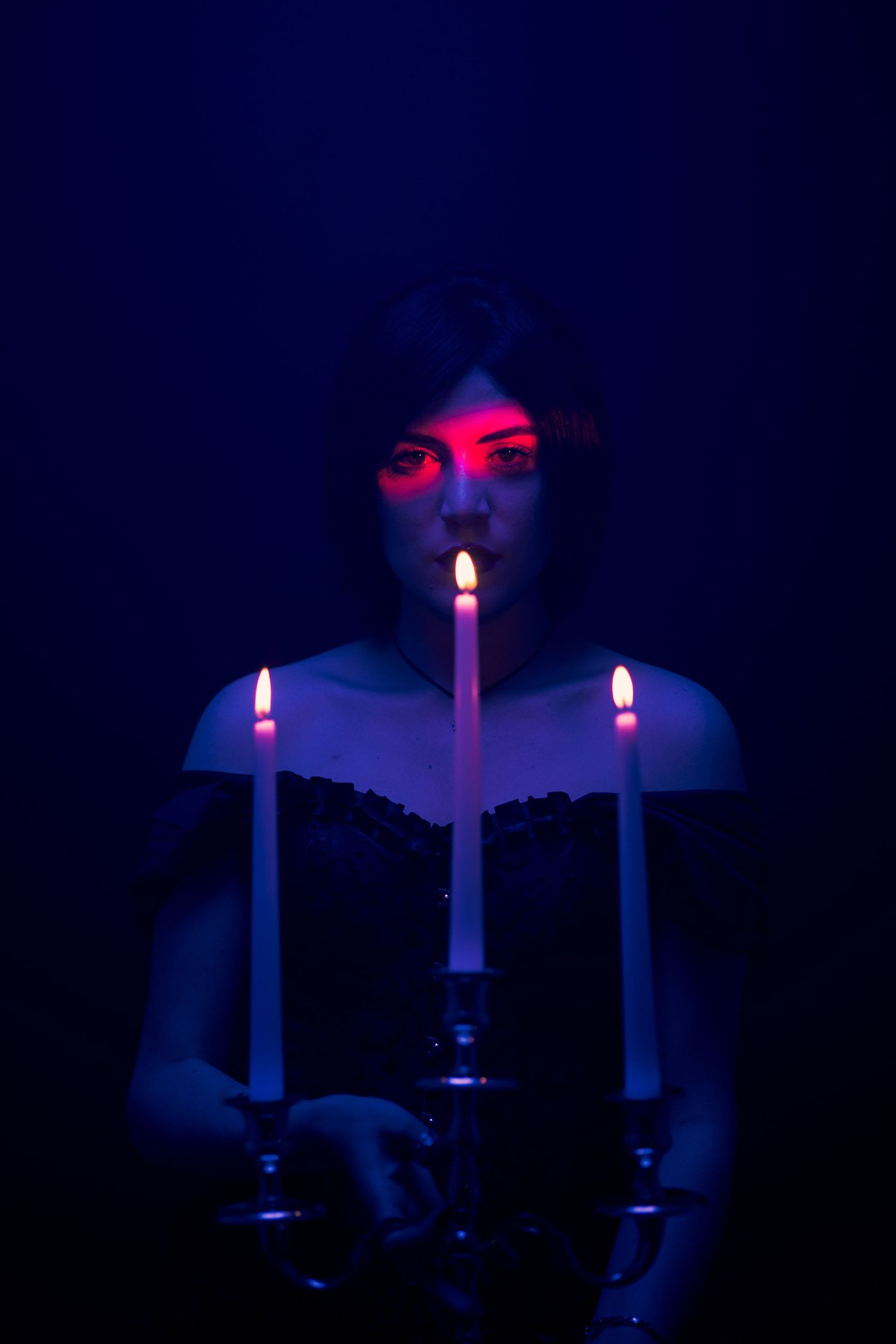 Experimental cinematic portrait with blue lighting and red light across the face