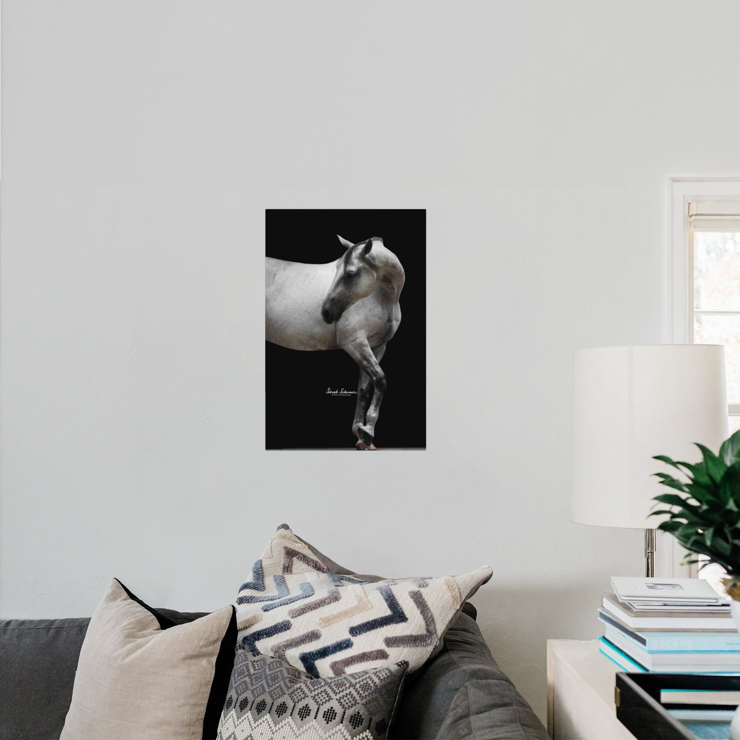 Two framed horse photography prints displayed above a sofa, showing close-up views of horse hindquarters and hooves.