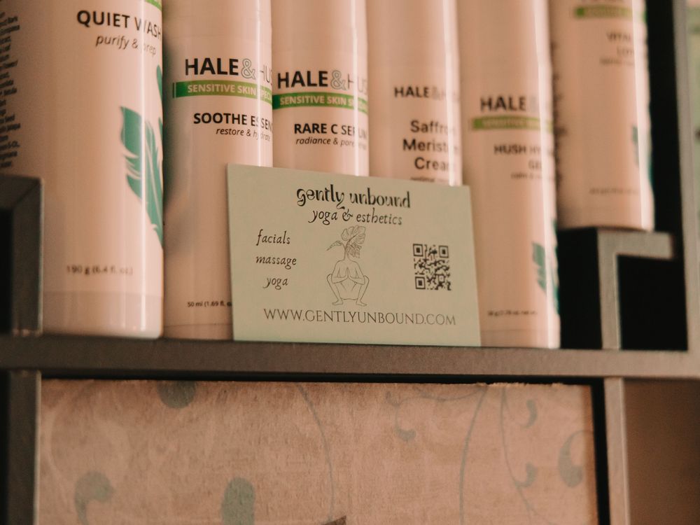 Esthetician business card in front of facial products and skin products