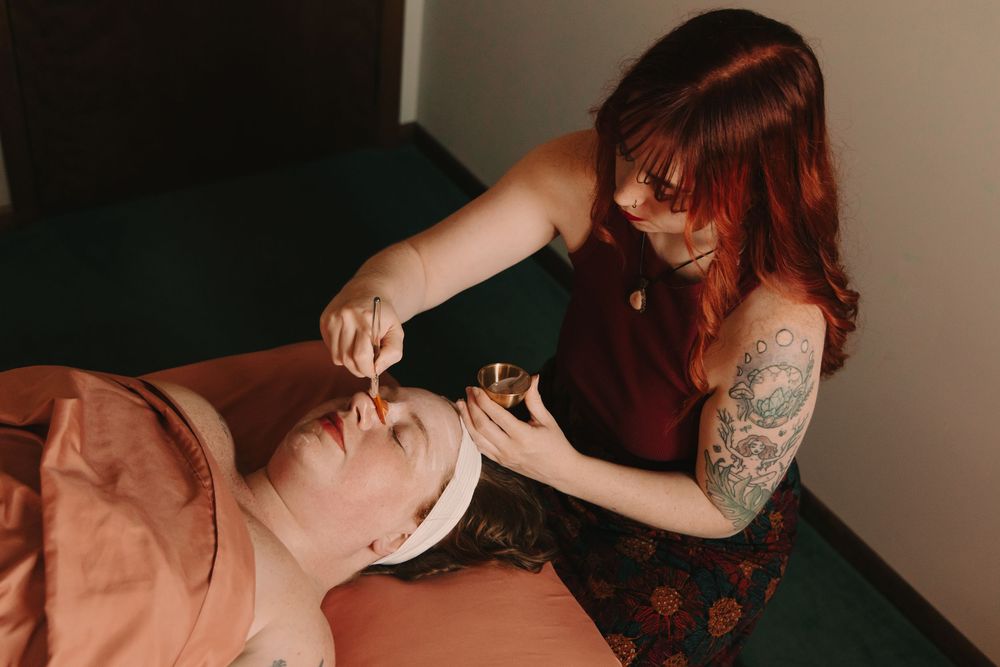 Esthetician applying a facial mask treatment