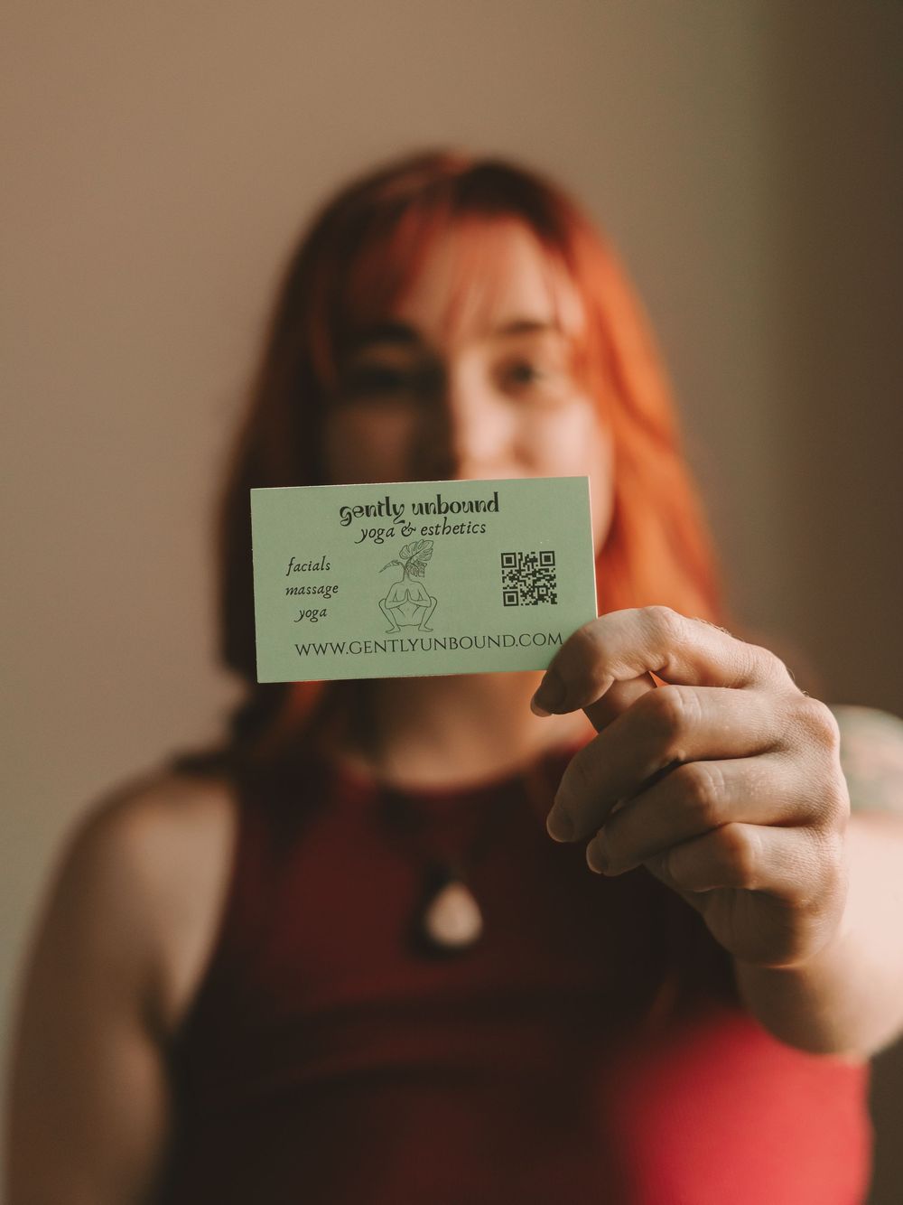 Esthetician holding a business card in front of her face