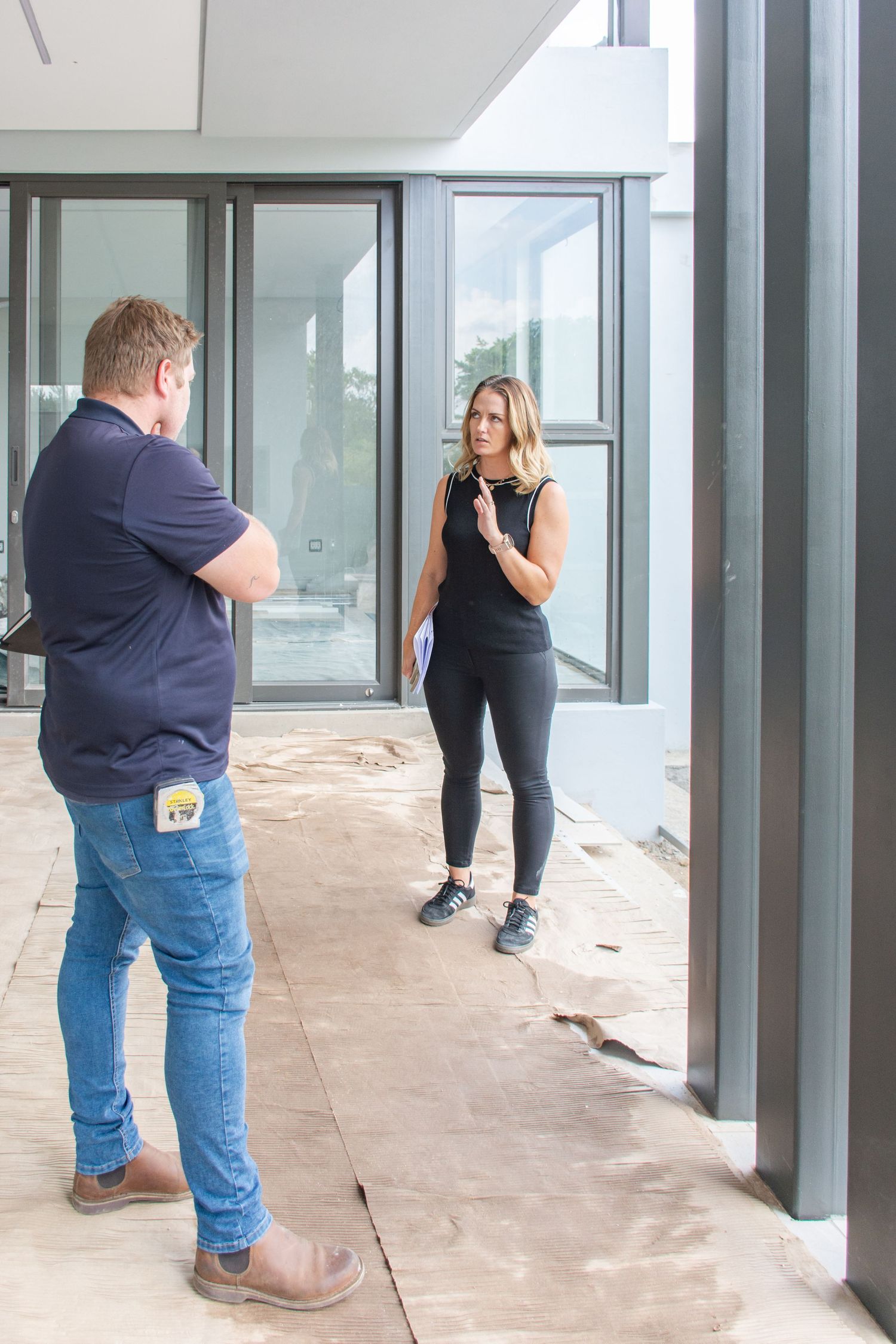 Lara gestures while discussing interior design and architectural points with a part of the construction team onsite.