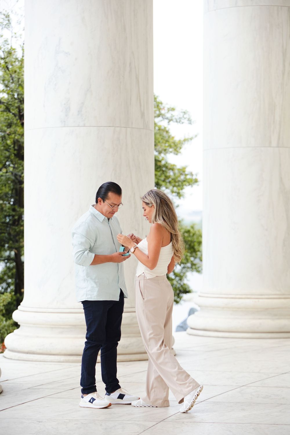 Couple sharing a romantic moment between marble columns at the Jefferson Memorial in Washington DC.