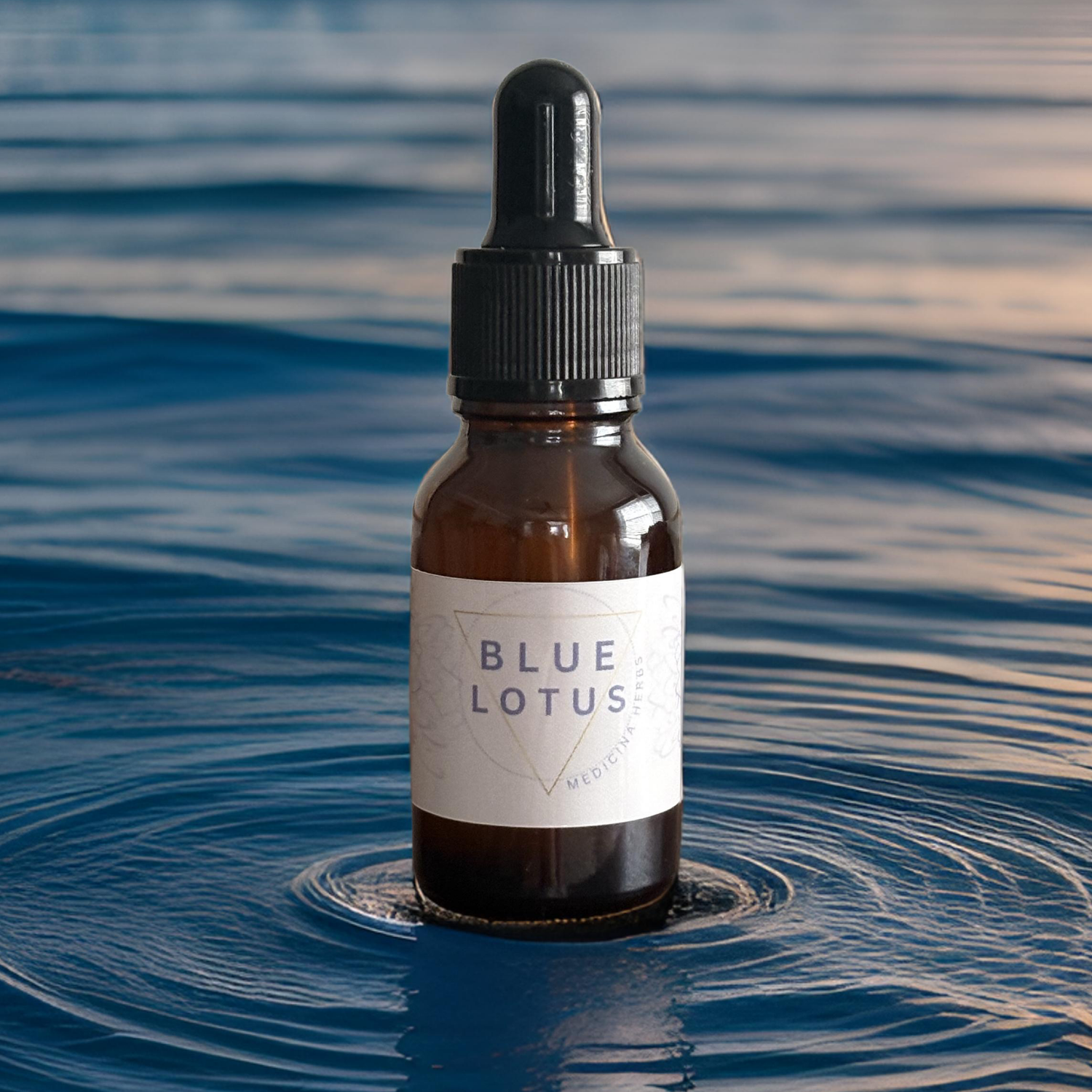 Amber dropper bottle of Blue Lotus extract standing in rippling blue water, minimalist label design.