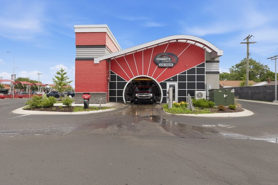 Exterior of Jimmys Car Wash with bold red and black facade, tunnel entrance, and spacious parking lot.