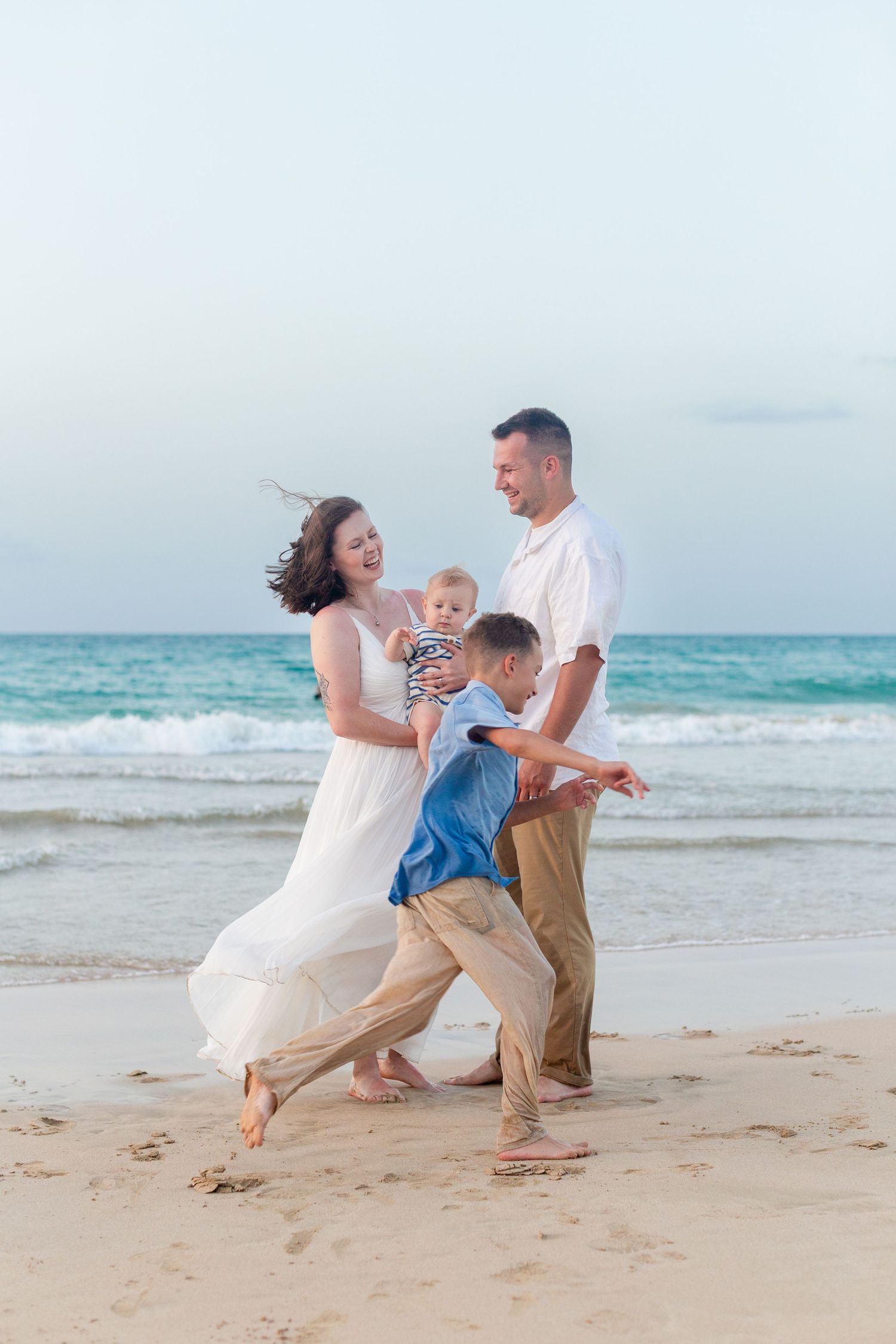 Family portrait on the beach in Isla Verde, Carolina, Puerto Rico. Father, mother and two sons.