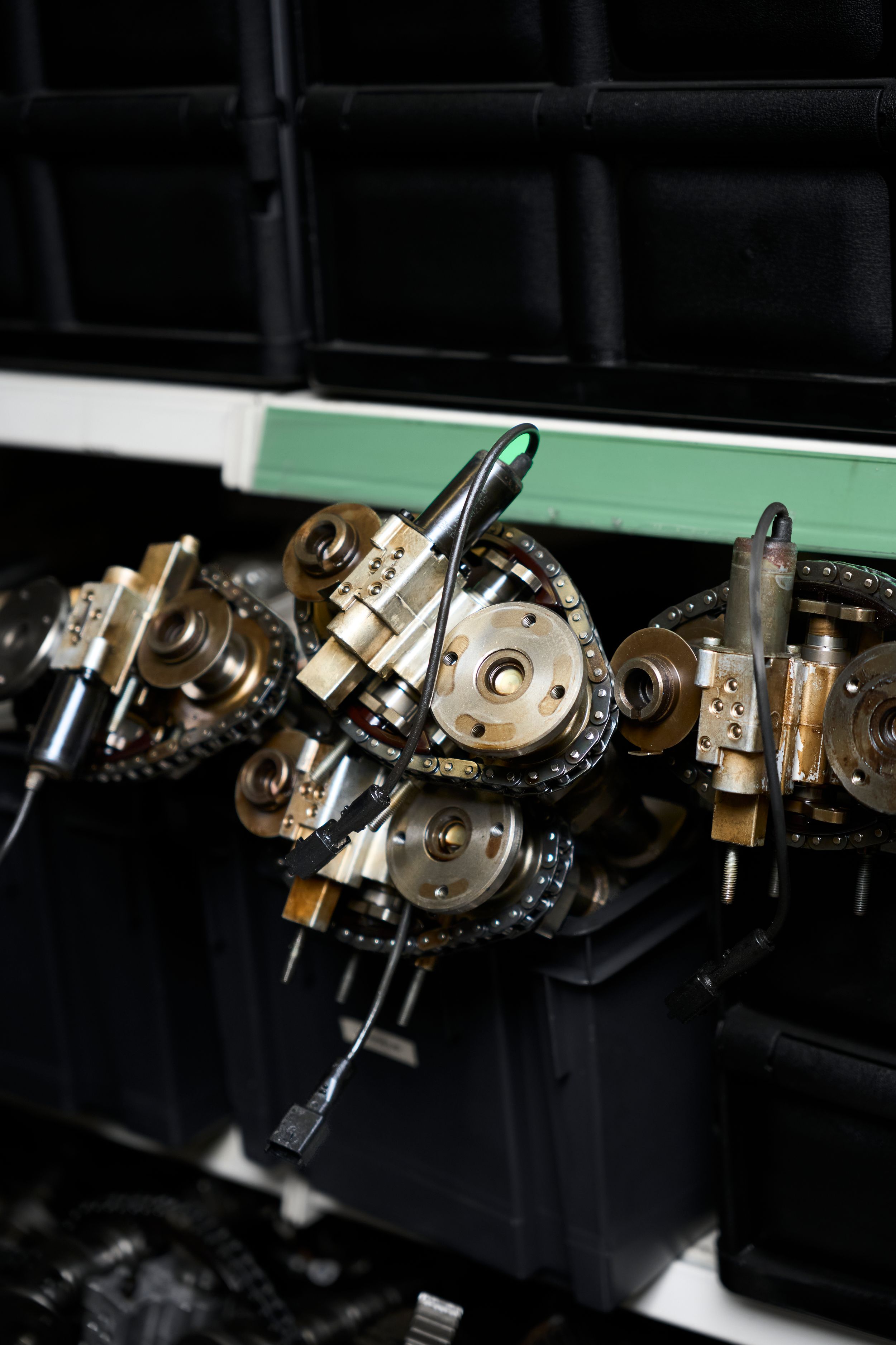 Close-up of brass camshaft gears and timing chain components on a workshop bench.