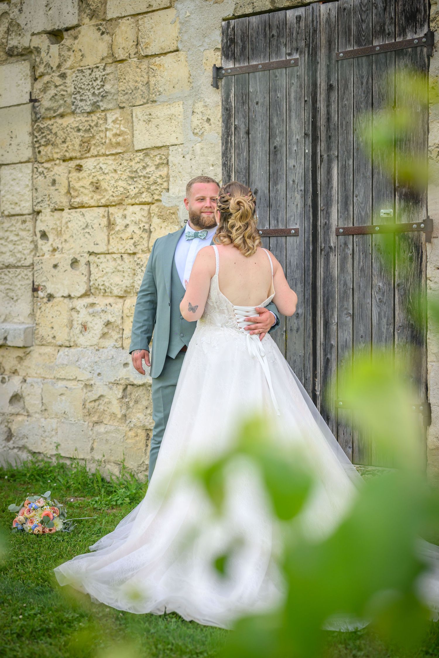 A romantic wedding couple poses in a series of elegant shots under stone archways at a historic European castle.