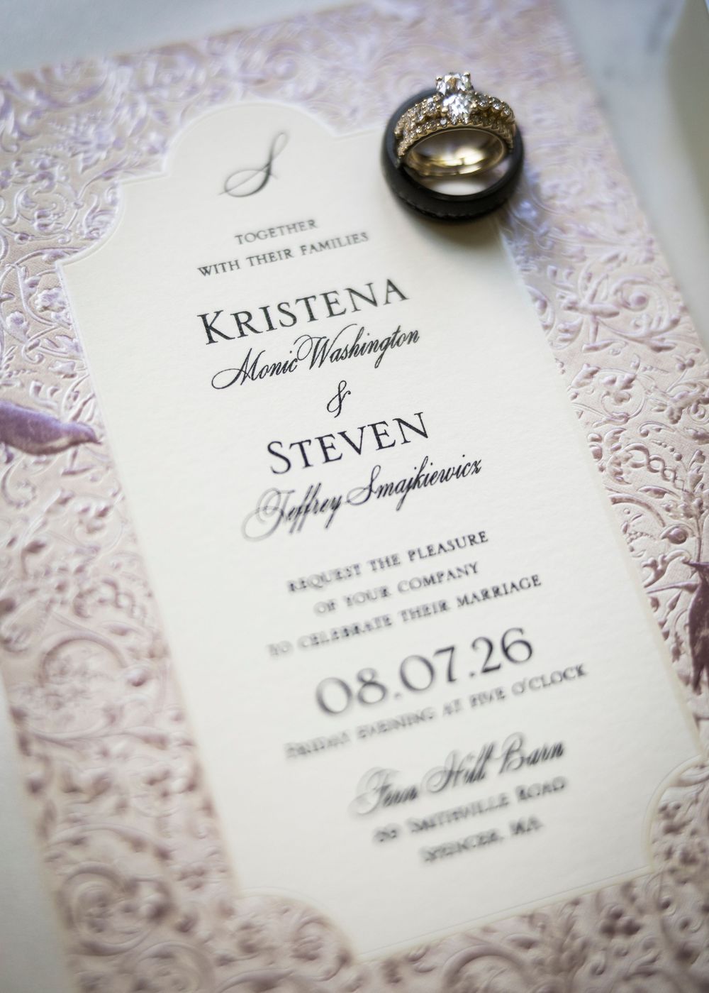 Elegant wedding invitation for Kristena and Steven with lace border, wedding rings, dated 08.07.26 at Iron Hill Barn.