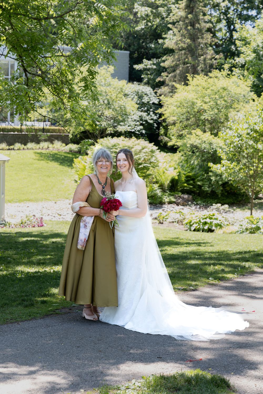 Bride stand close with mother surrounded by greenery at the civic garden complex in london, ontario.