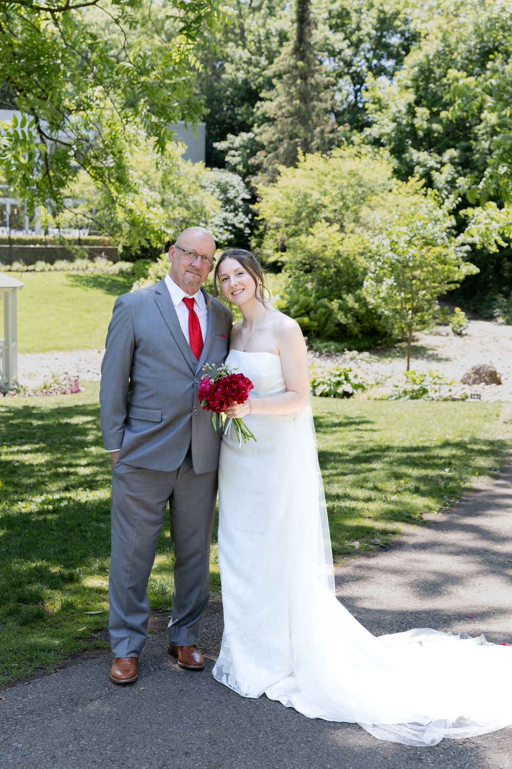 Bride and her father stand together surrounded by greenery at the civic garden complex in london, ontario.
