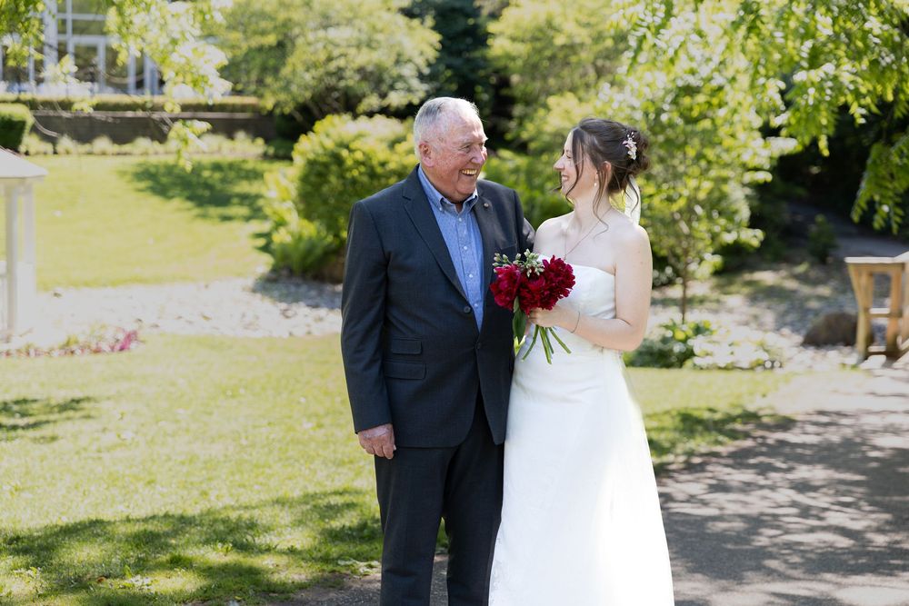 Bride sharing a look with her grandpa surrounded by greenery at the civic garden complex in london, ontario.
