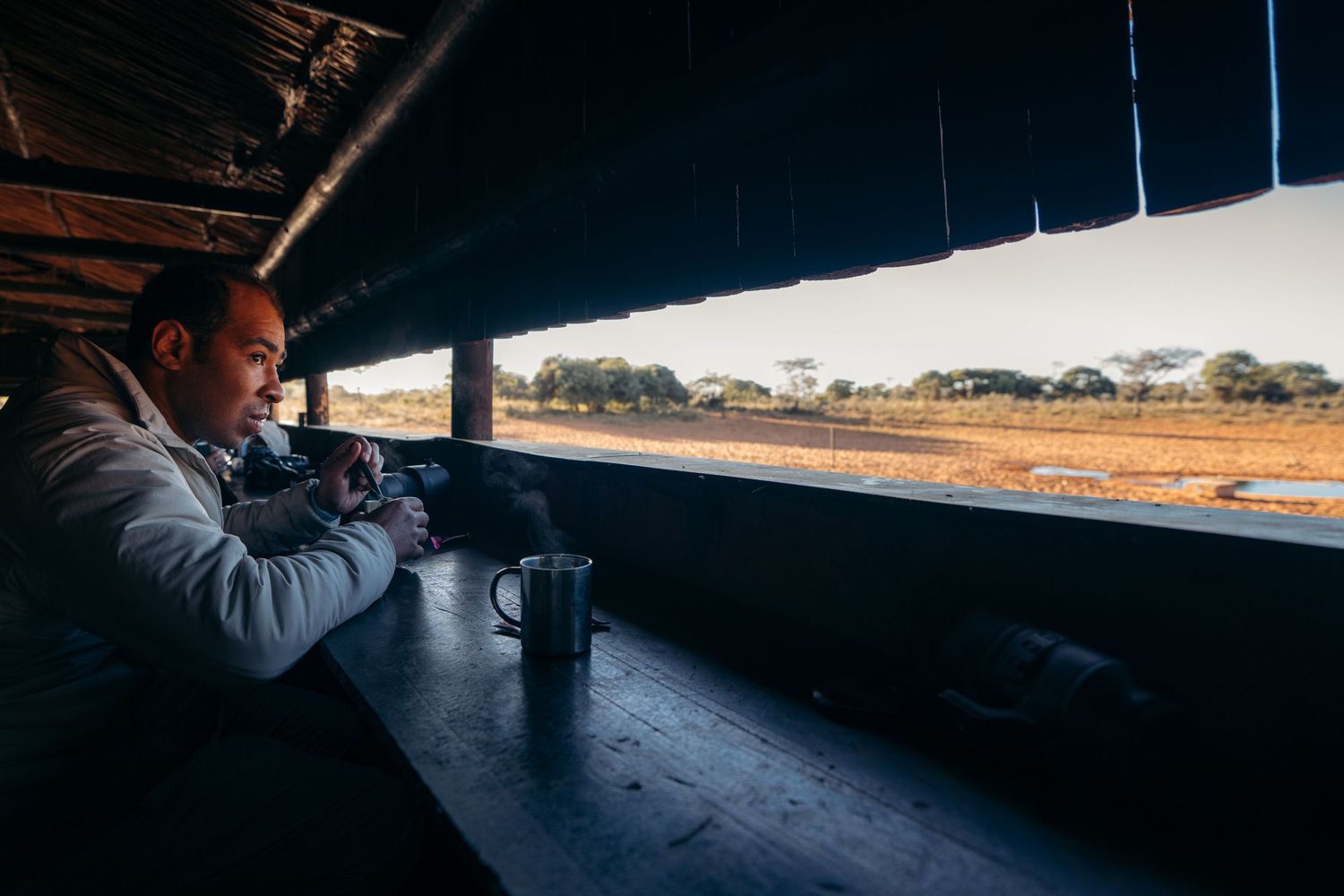 homme qui regarde les aniaux dans un poste d'observation à waterberg