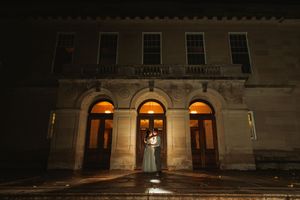 Historic building entrance illuminated at night with arched doorways.