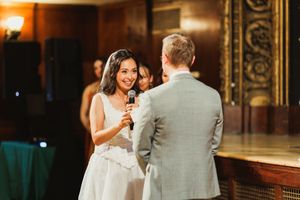 A couple shares their first dance at their wedding reception in an elegant ballroom.