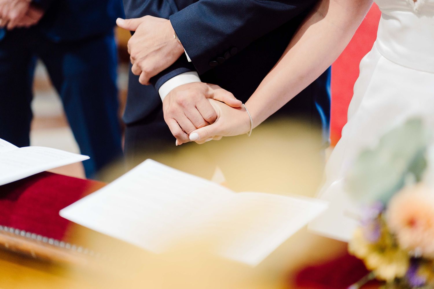 Newlyweds exchanging wedding rings at a ceremony table, symbolizing their marriage commitment.
