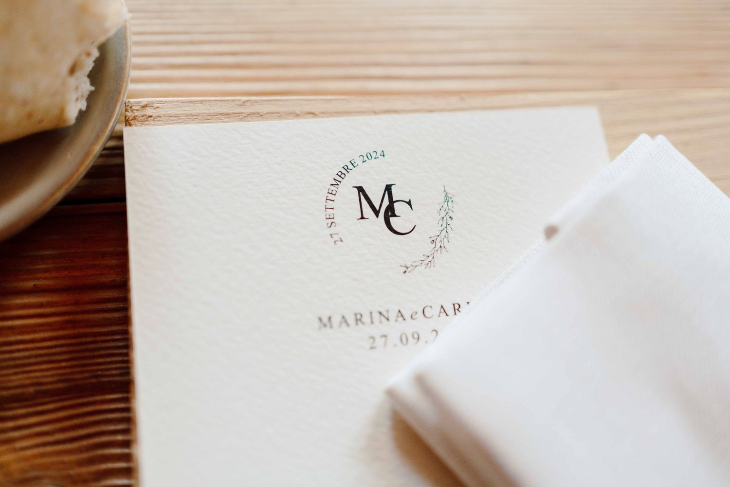 Elegant wedding stationery with monogram MC and date 27.09, printed on textured white paper.