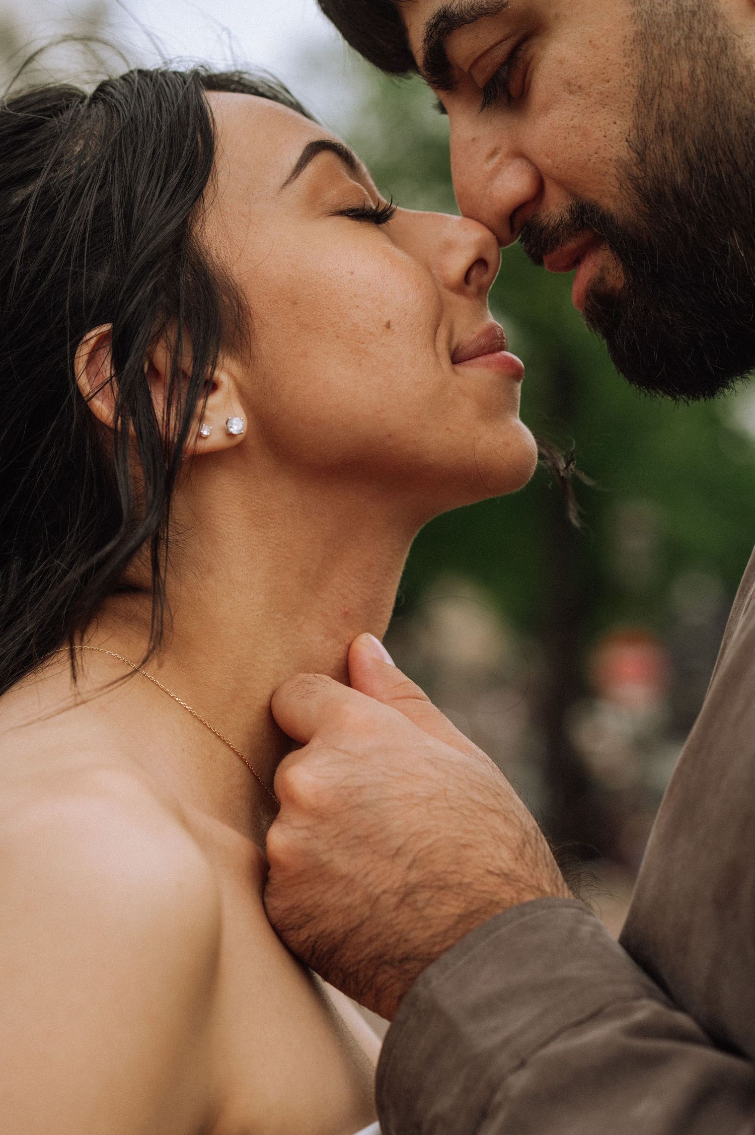 Romantic couple touching noses in an intimate close-up as he gently holds her neck, photoshoot in Amsterdam.